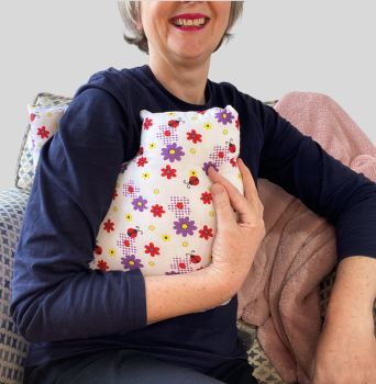 My breast cancer surgery support pillows are ideal for use directly after surgery, or in the following weeks while healing takes place. This support pillow is shaped to fit comfortably under the affected arm, and is filled with high quality polyester filling to a fairly firm finish, perfect to provide adequate support and comfort. This pillow reaches mid chest in width, so it will easily cover the surgery area, and provide support&nbsp; and padding.
It measures 43cm wide X 37cm long and 10 cm in depth. This has ladybirds and purple flowered cotton fabric and is soft and breathable. All pillows come with a I love handmade label, and are fully reversible.