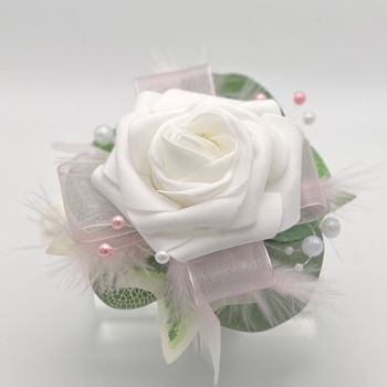 A pretty keepsake Debs wrist corsage made with an artificial white rose and attached to a white pearl bracelet.