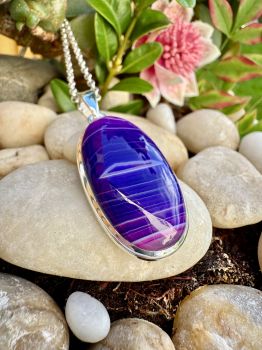 This beautiful Purple and Pink Hues Botswana Agate Sterling Silver Necklace is a unique handmade piece that will make a statement with any outfit. The gorgeous pink and Purple hues of the Botswana Agate stone are bezel set in sterling silver, perfect for adding a touch of class to any look, this necklace is a one-of-a-kind piece and a great addition to any jewelry collection.