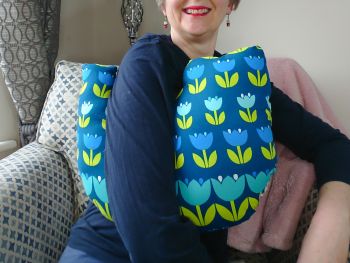 My breast cancer surgery support pillows are ideal for use directly after surgery, or in the following weeks while healing takes place. This support pillow is shaped to fit comfortably under the affected arm, and is filled with high quality polyester filling to a fairly firm finish, perfect to provide adequate support and comfort.
This pillow reaches mid chest in width, so it will easily cover the surgery area, and provide support&nbsp; and padding. It measures 43cm wide X 37cm long and 10 cm in depth. This has large blue coloured tulips with lime green leaves flowered print fabric and is soft and breathable. All cushions come with a made with love by Rodgerson Handcraft label and are reversible.