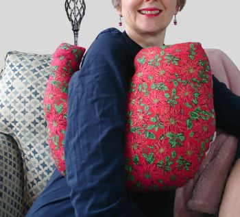 My breast cancer surgery support pillows are ideal for use directly after surgery, or in the following weeks while healing takes place. This support pillow is shaped to fit comfortably under the affected arm, and is filled with high quality polyester filling to a fairly firm finish, perfect to provide adequate support and comfort.
This pillow reaches mid chest in width, so it will easily cover the surgery area, and provide support&nbsp; and padding.It measures 43cm wide X 37cm long and 10 cm in depth. This has festive red poinsettia flowered fabric. It is super soft and breathable. All pillows come with a made with love by Rodgerson Handcraft label and are reversible.