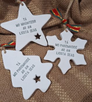 M&uacute;inteoir decorations . These are handcrafted using air drying clay and are approximately 8cm, they come on festive ribbon. They are made to order so please allow up to 1 week processing. These are not suitable for outdoor use and should be kept away from water and extreme temperatures. 2 styles to choose from a Tree and a star&nbsp; and snowflake - but please note on the snowflake I may not be able to fit your childs name if you wanted it personalised