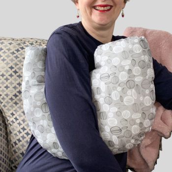 My breast cancer surgery support pillows are ideal for use directly after surgery, or in the following weeks while healing takes place. This support pillow is shaped to fit comfortably under the affected arm, and is filled with high quality polyester filling to a fairly firm finish, perfect to provide adequate support and comfort.&nbsp;
This pillow reaches mid chest in width, so it will easily cover the surgery area. &nbsp;It measures 43cm wide X 37cm long and 10 cm in depth. This shades of grey and white circle outlines fabric is soft and breathable. All pillows come with a made with love by Rodgerson Handcraft label and are reversible.