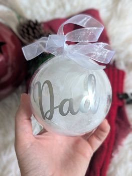 Add a touch of elegance to your Christmas tree with our personalized feather-filled baubles, crafted from high-quality, eco-friendly plastic. This 100mm ornament is a beautiful keepsake and a thoughtful gift, featuring a customizable vinyl name and a delicate organza ribbon. Available in various font colours, it's perfect for celebrating Christmas year after year.
