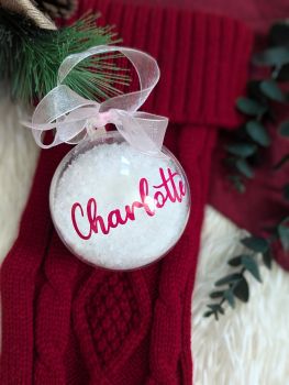 &nbsp;
Celebrate a baby's first Christmas with our personalized 80mm snow-filled bauble, made from eco-friendly plastic. Featuring a custom name, this keepsake ornament comes with an organza ribbon and vinyl lettering in various colours. A perfect addition to your tree or a thoughtful gift.